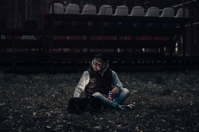 Full length of woman sitting on field