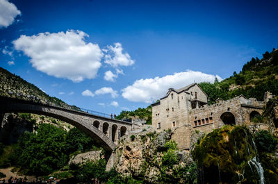 Low angle view of arch bridge and building against sky