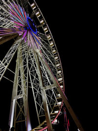 Low angle view of illuminated ferris wheel against sky at night