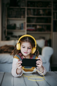 Girl holding smart phone at home