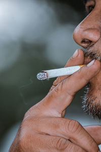 Close-up portrait of the cigarette from a man who's smoking