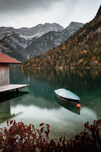 Scenic view of lake by mountains against sky