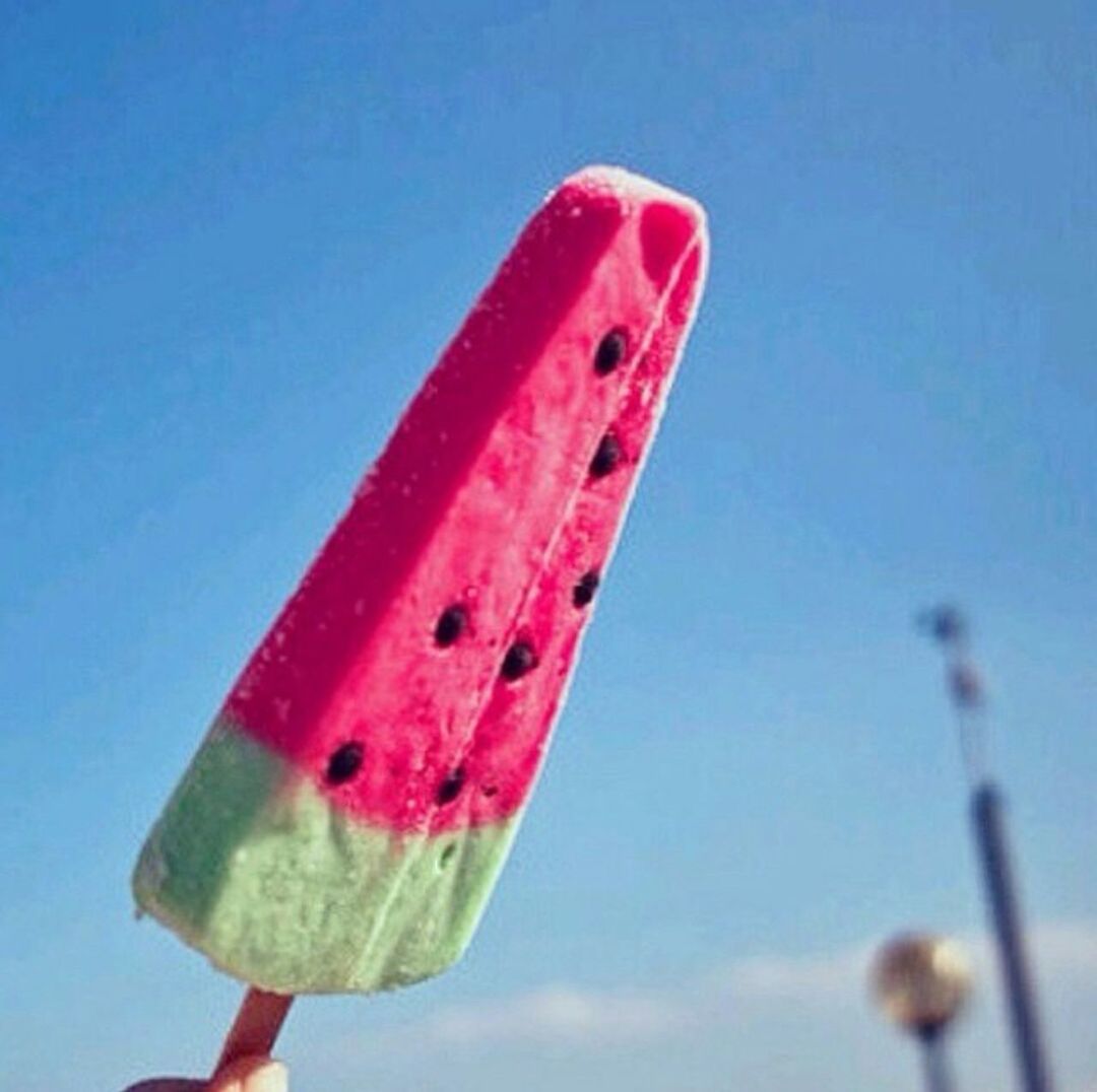 red, blue, food and drink, close-up, clear sky, copy space, freshness, part of, low angle view, holding, focus on foreground, sky, cropped, day, food, single object, multi colored, outdoors, studio shot, fruit