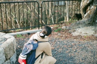 Side view of woman sitting on rock