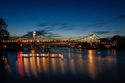 View of bridge over river at night