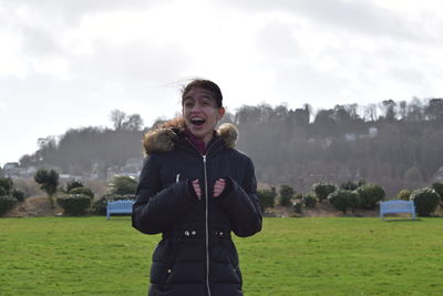 Cheerful girl wearing warm clothing while standing on land