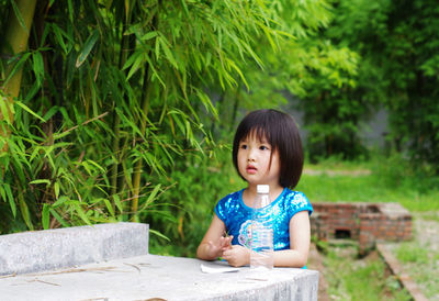 Girl looking away by trees at park