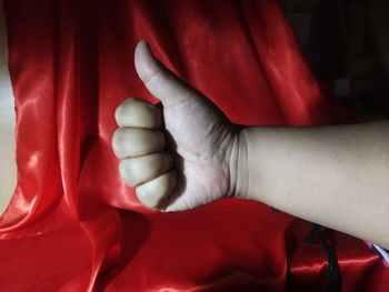 Close-up of human hand on bed