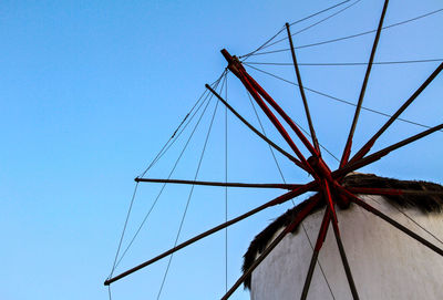 Low angle view of electricity pylon against blue sky