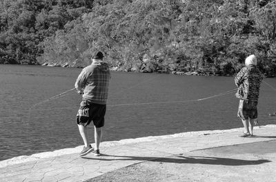 Rear view of man walking by water