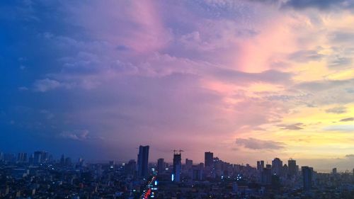 Buildings in city against sky during sunset