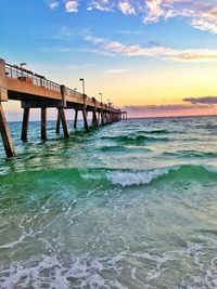 Pier over sea against sky during sunset