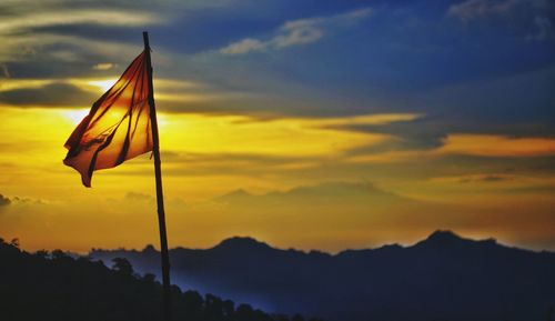 Close-up of silhouette flag against sky during sunset