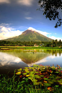 Scenic view of lake by mountains against sky