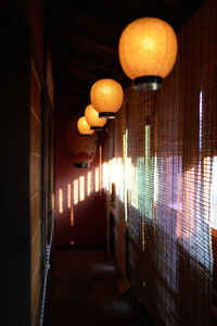 Illuminated lanterns hanging on wall in building