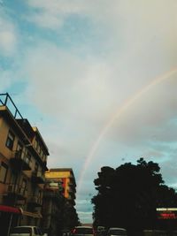 Low angle view of rainbow over buildings in city