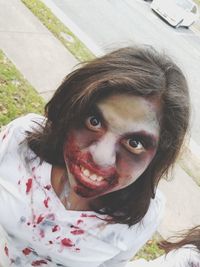 High angle portrait of young woman with zombie make-up at front yard