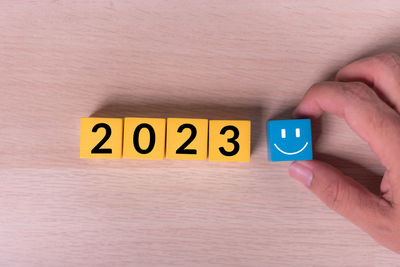 Cropped hand of person holding text on wooden table