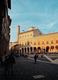 People on street against buildings in city