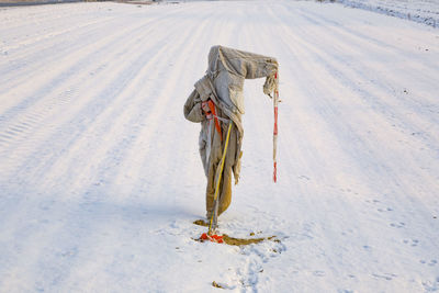 Rear view of woman walking on snow covered field