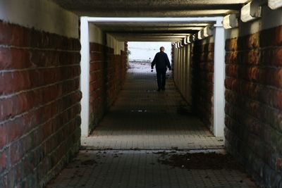 Rear view of man walking in corridor