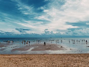 A group of people standing on a dreamy beautiful beach.