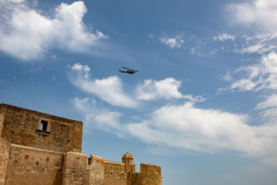 An airplane flies over an old medieval castle, to unify the old and the new world