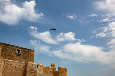 Low angle view of airplane flying against sky