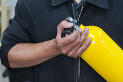 Close-up midsection of man holding diving equipment