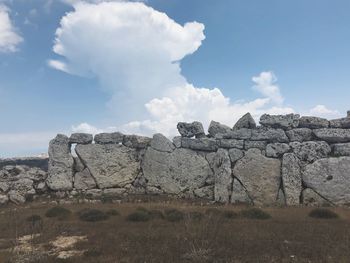 Rocks on field against sky