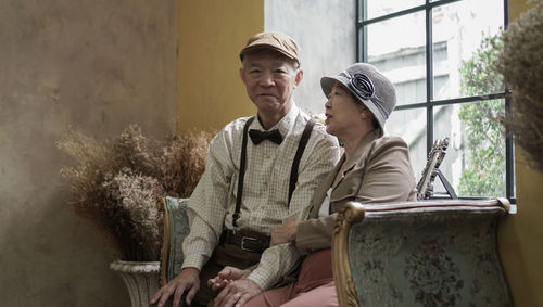 Vintage retro classic dress asian senior elder couple taking photo at luxury home together