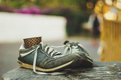 Close-up of shoes on retaining wall