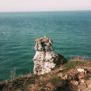 Rock formation on sea against sky