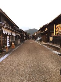 Road passing through town against clear sky