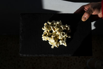 Gourmet popcorn on top of a black plate.
