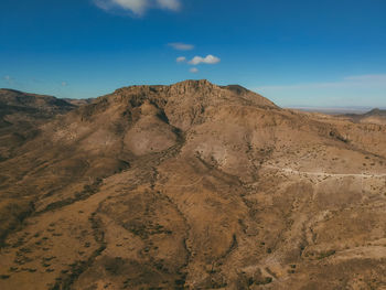 Scenic view of desert against blue sky