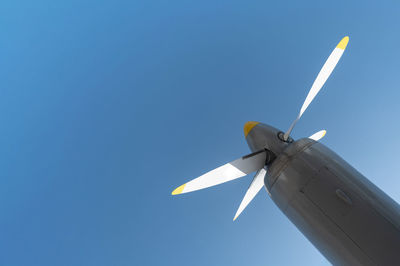 Low angle view of airplane flying against clear blue sky