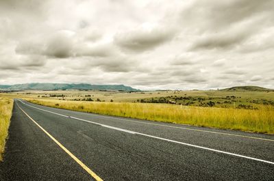 Empty road along countryside landscape