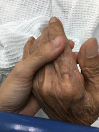 Close-up of man hand on bed