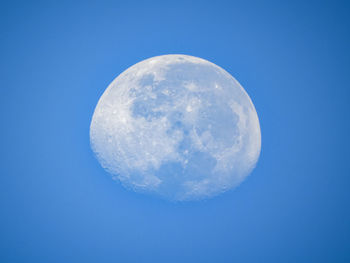 Low angle view of moon against blue sky