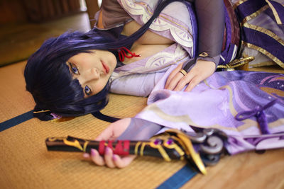 High angle view of young woman sitting on bed at home