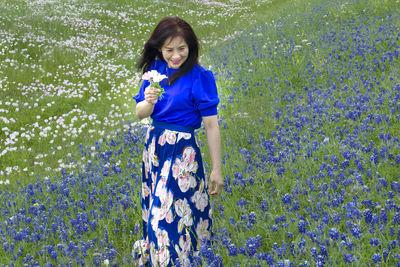 Portrait of smiling young woman standing on field