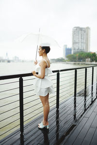 Full length of woman standing against railing