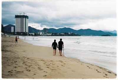 Men on beach against sky