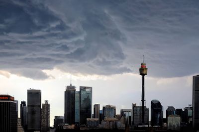 Buildings in city against cloudy sky