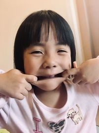 Close-up portrait of cute asian girl making funny face