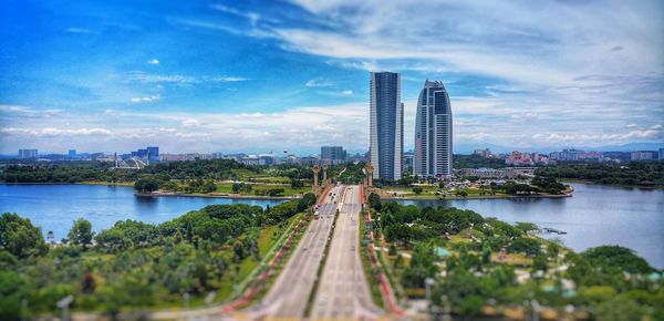 Panoramic view of city by river and buildings against sky
