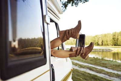 Woman wearing boots resting in camping van