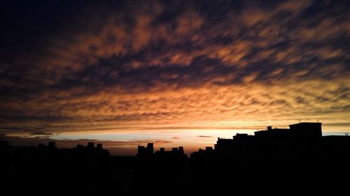 Silhouette buildings against sky during sunset