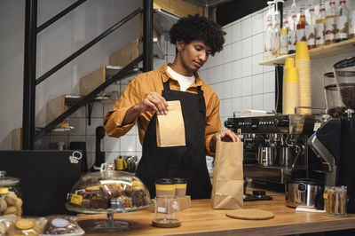 Barista packing takeaway package at coffee shop